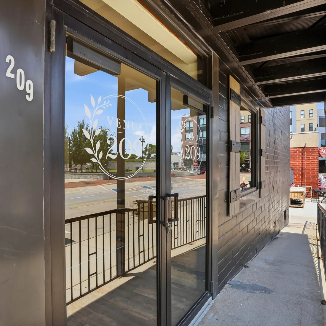 The etched glass entrance doors of Venue 209 at 209 State Street, looking out onto downtown Cedar Falls, Iowa
