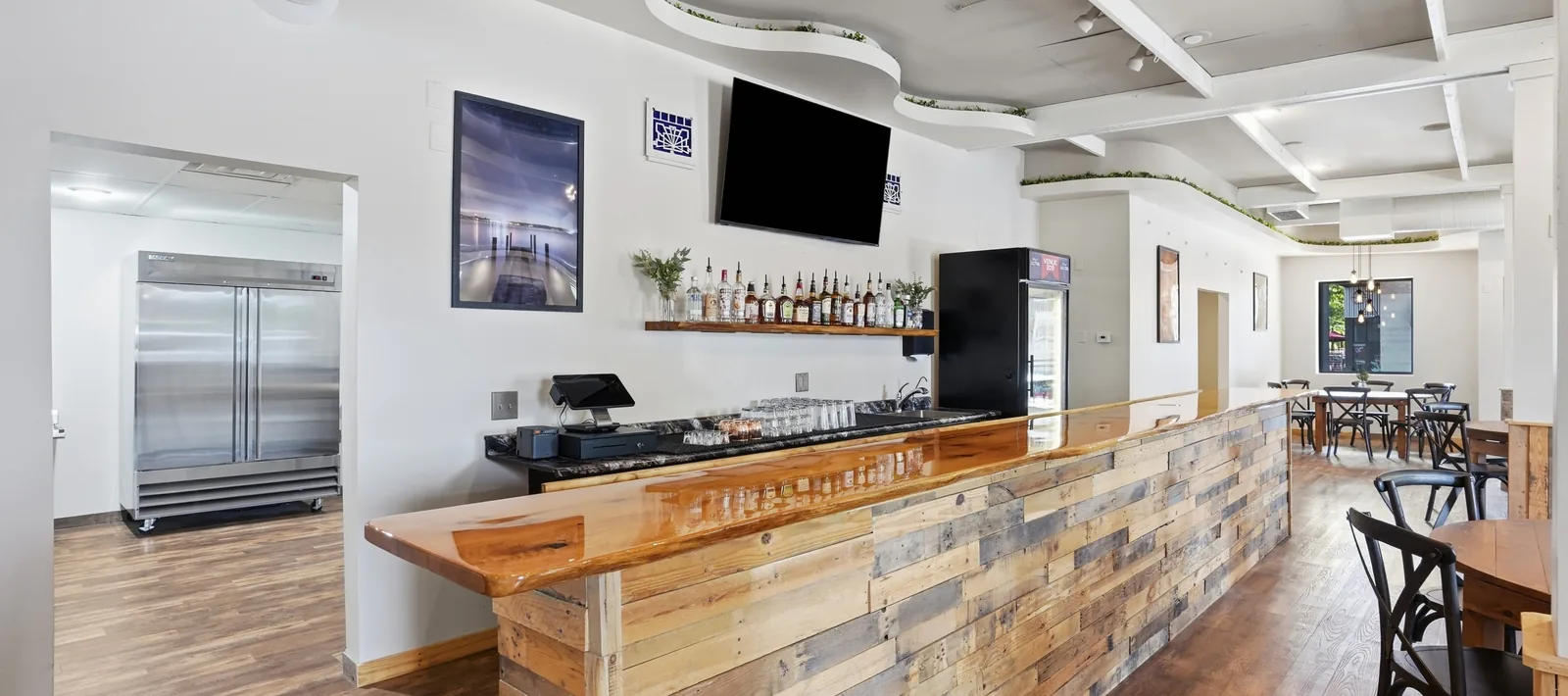 The full-length reclaimed wood bar at Venue 209 with a live-edge poured top, served by Cypress Lounge
