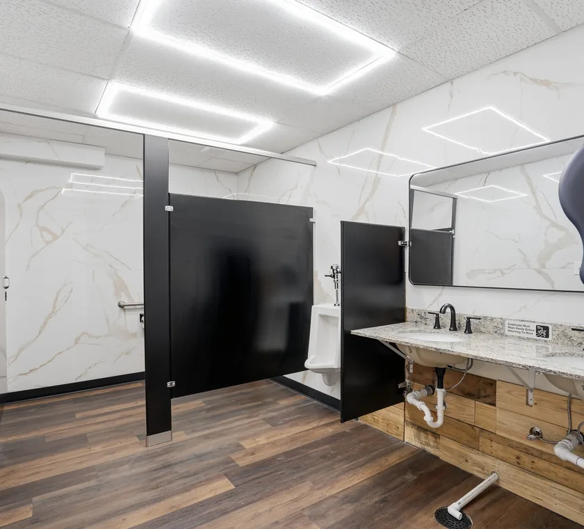 Guest restrooms at Venue 209 finished in marble-look tile with a granite double vanity