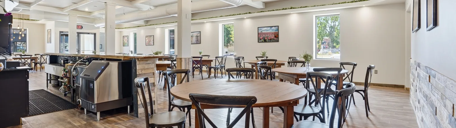 A wide view across the main hall at Venue 209 from the bar toward the front windows