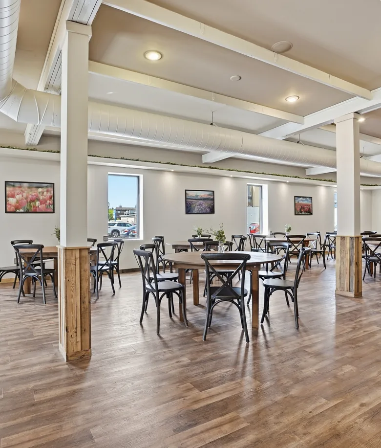 Round tables and cross-back chairs set for an event in the main hall at Venue 209